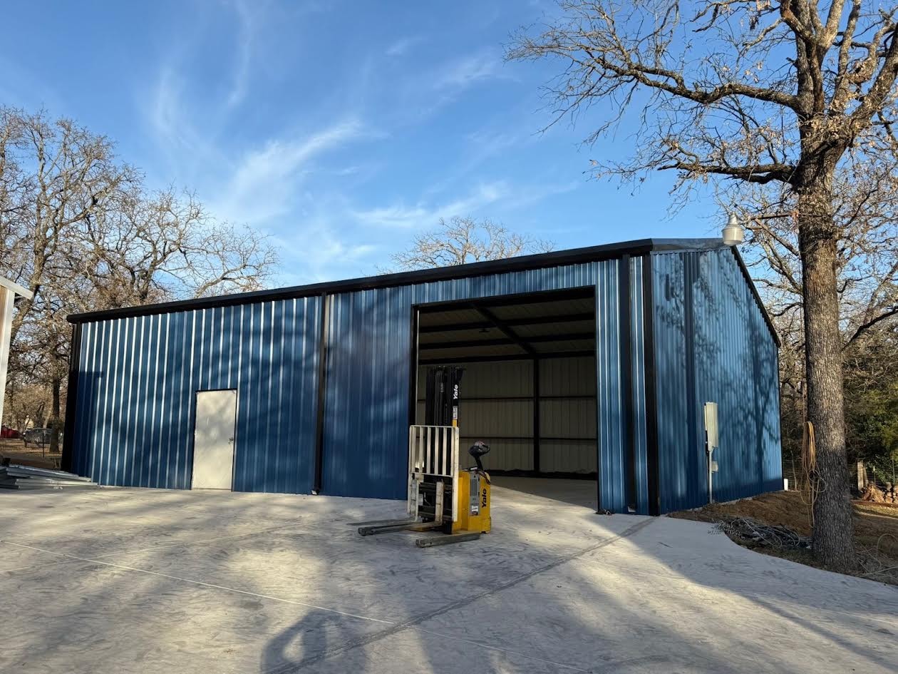 Blue metal commercial building with forklift and open bay