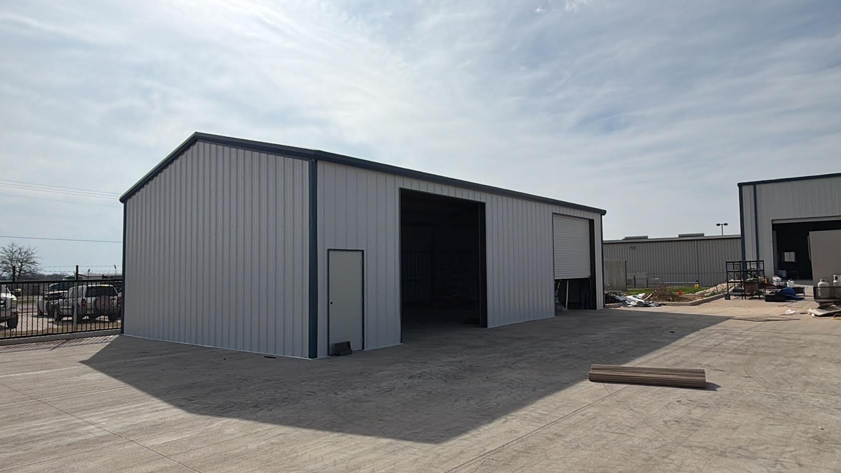 White metal commercial building with large roll-up door