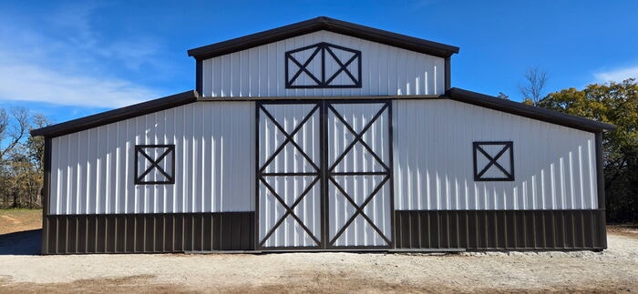 Post frame barn with white siding and black trim
