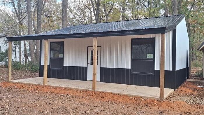 Post frame building with covered porch and wood posts
