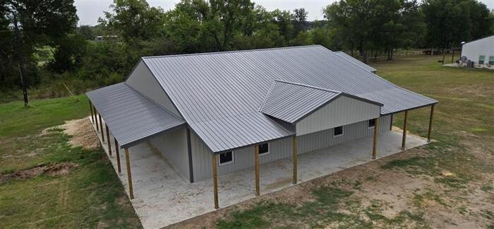 Aerial view of large post frame building with lean-tos
